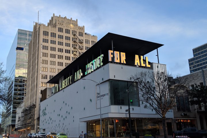 View of a building with white walls and blue blocks. With the words 