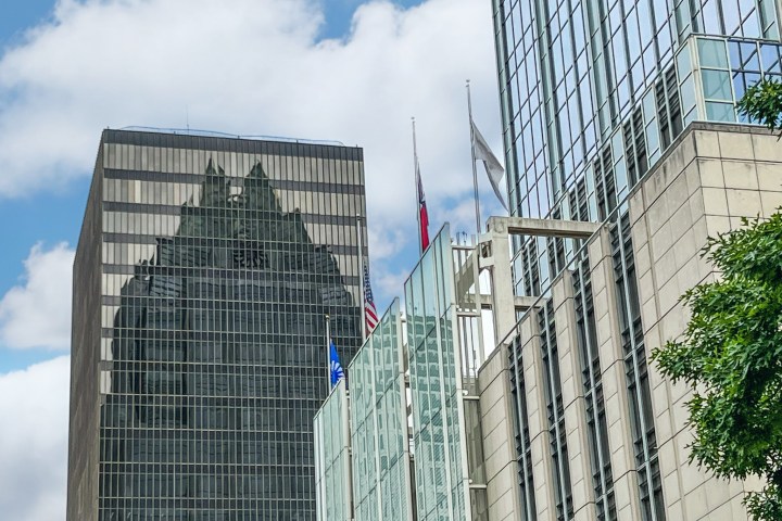 View of tall glass skyscrapers in Austin, Tx. Reflection of the Front Bank Tower on a brown glass building.