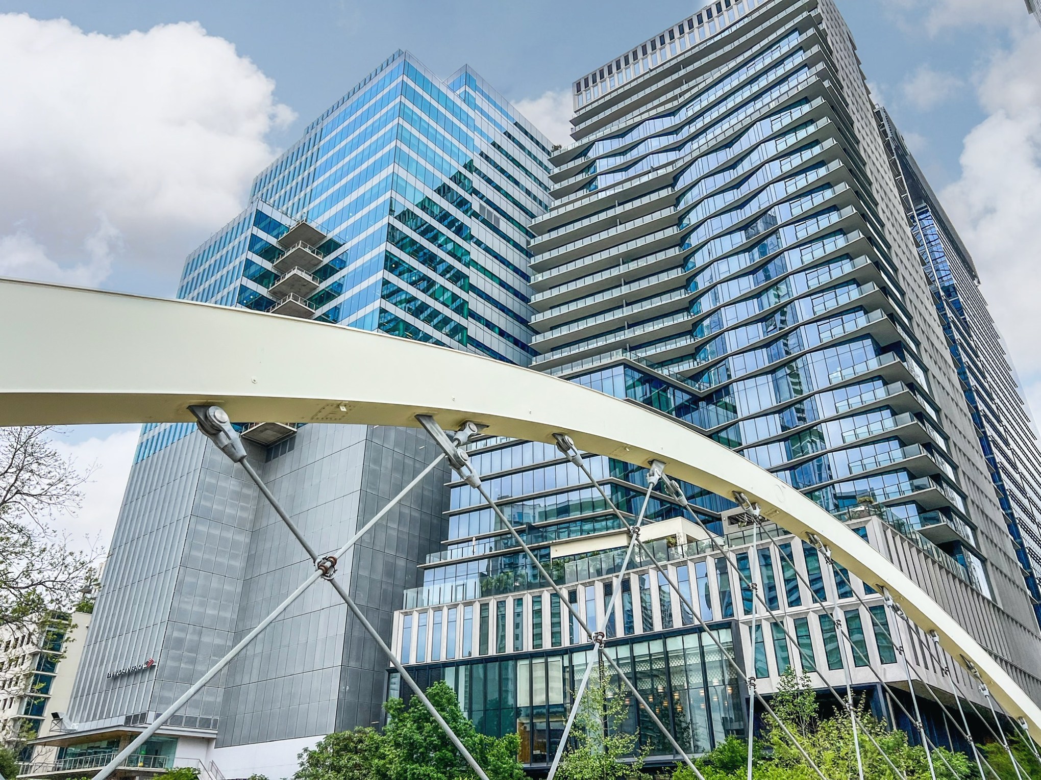 Butterfly bridge in Austin, Tx. View through white metal bridge arches of a tall glass building.