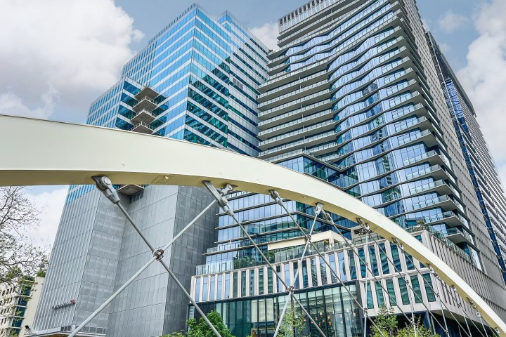 Butterfly bridge in Austin, Tx. View through white metal bridge arches of a tall glass building.