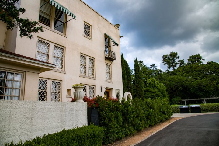 a large brick building with grass in front of a house