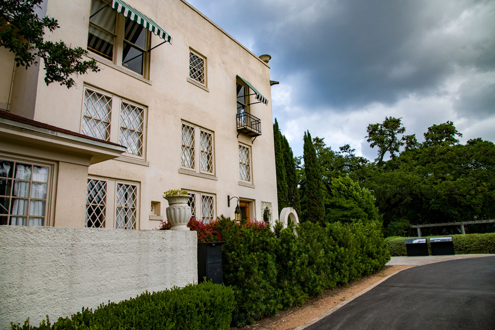 a large brick building with grass in front of a house