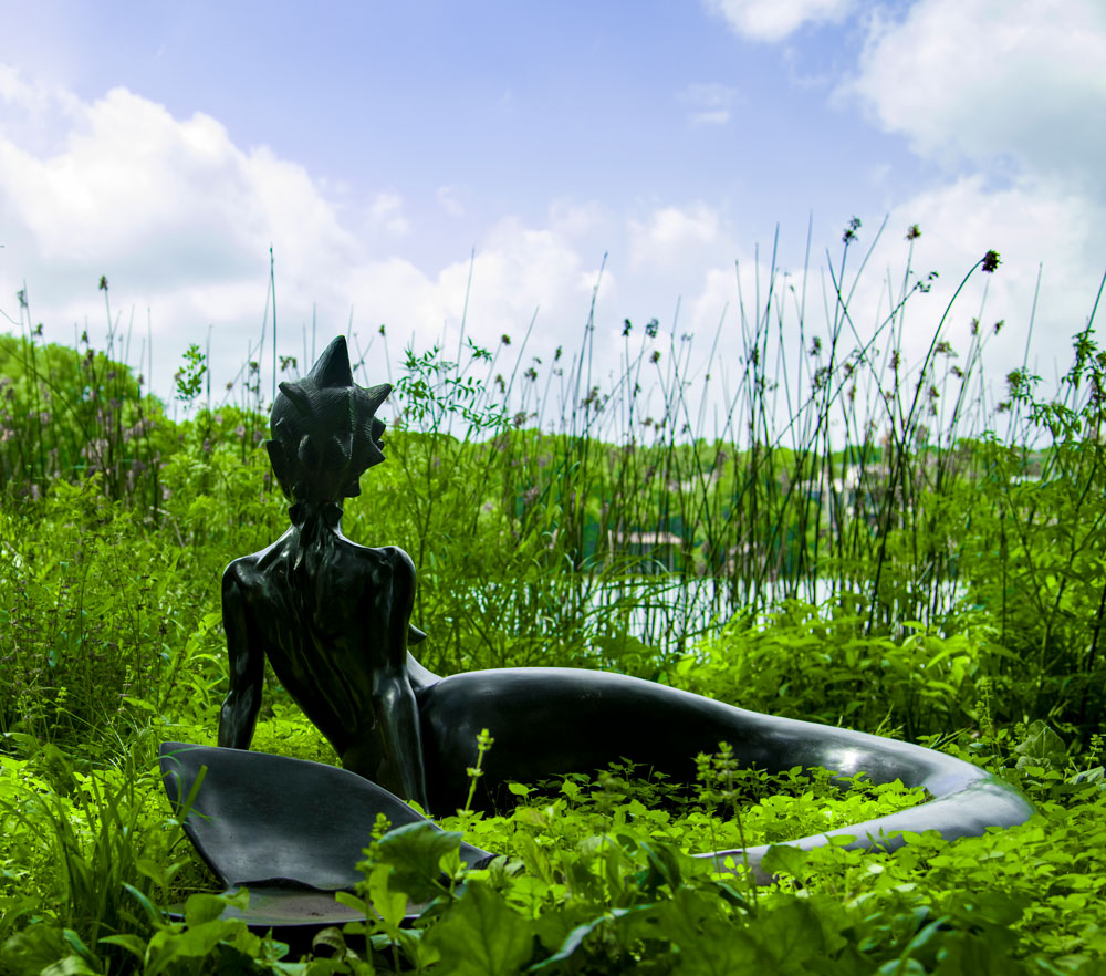 a statue in front of a body of water
