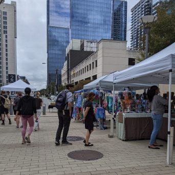 a group of people walking around at SFC farmers market downtown Austin