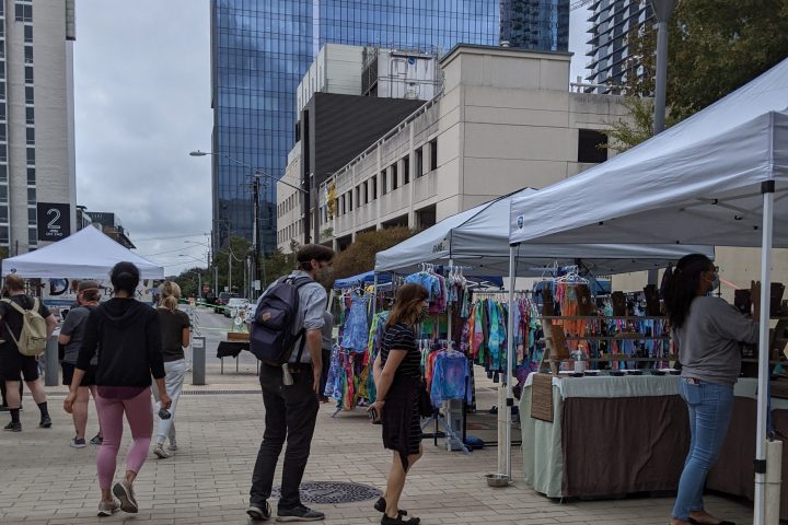 a group of people walking around at SFC farmers market downtown Austin
