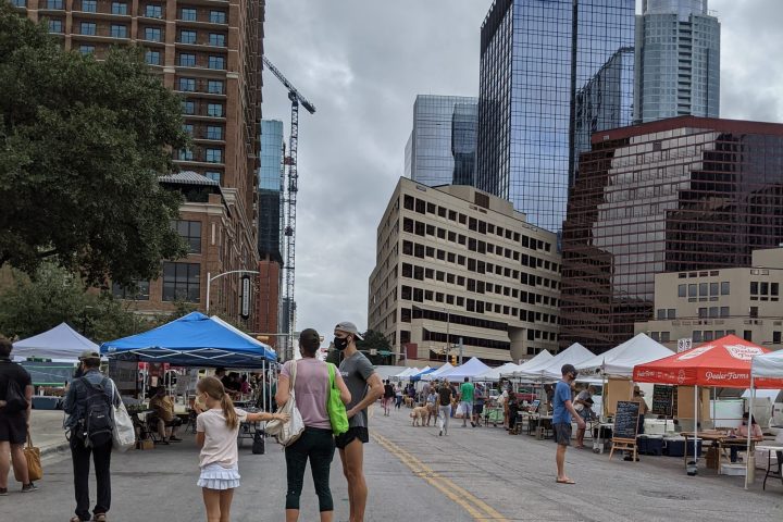 a group of people walking around at SFC farmers market downtown Austin