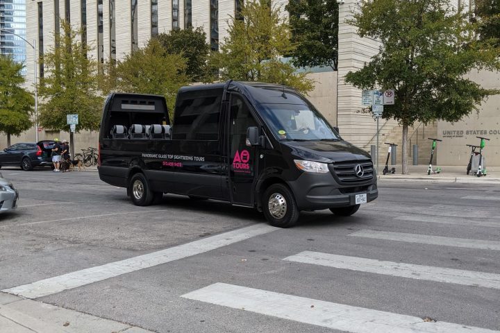 Black AO Tours Austin Panoramic Bus in front of Federal Courthouse in Austin, Texas